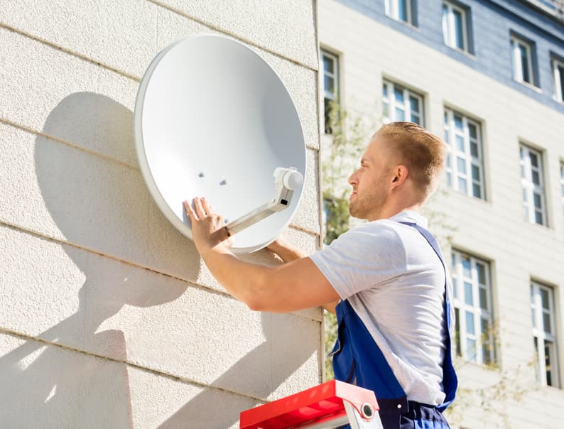 Man fixing satellite dish