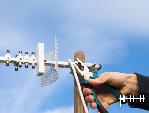 A man holding a cutter to fix a roof TV aerial