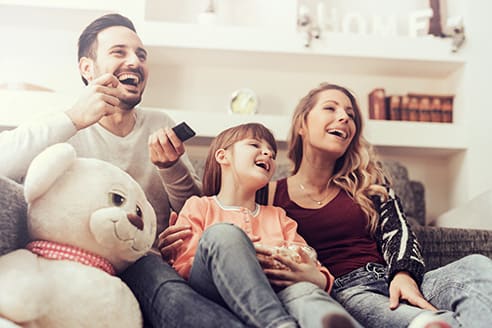 parents with daughter watching tv